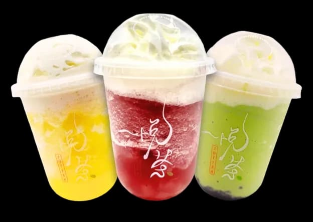 Three colorful iced drinks: a golden fruit tea, a red slush topped with whipped cream, and a green matcha with boba pearls